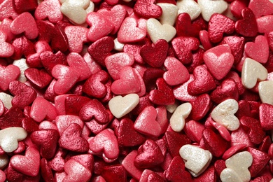 Photo of Sweet candy hearts as background, top view