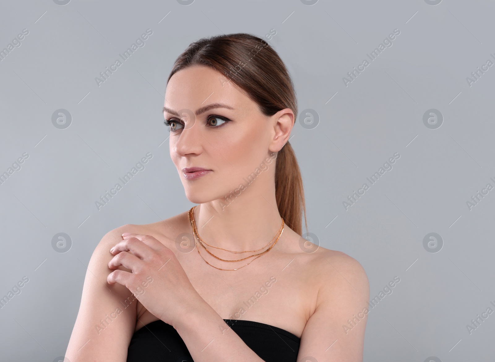 Photo of Beautiful woman with elegant necklace on light grey background