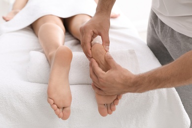 Photo of Young woman receiving massage in salon, closeup