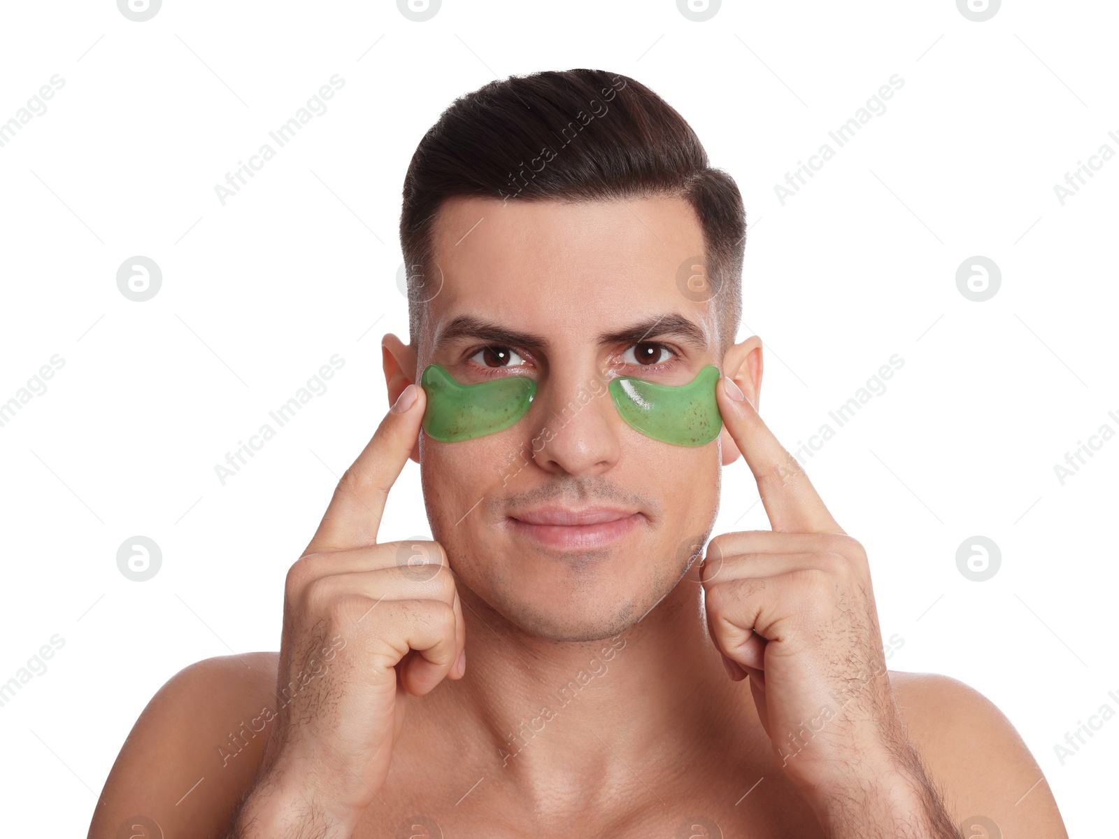 Photo of Man applying green under eye patches on white background