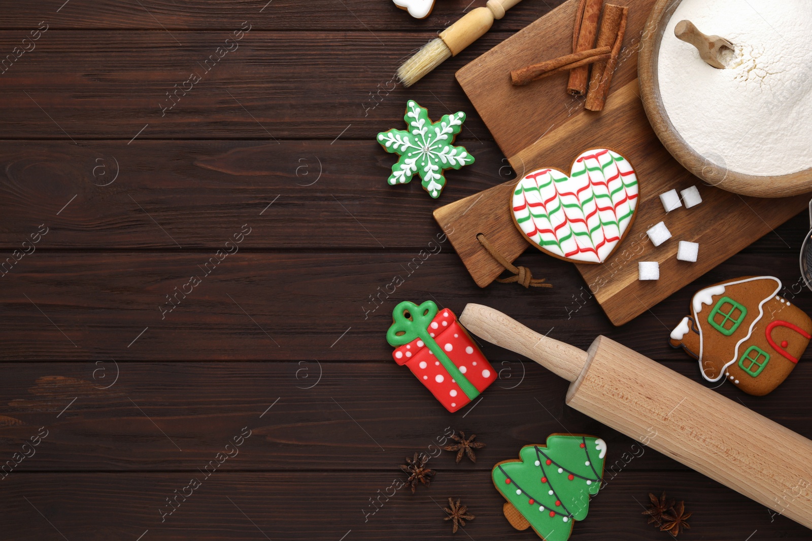 Photo of Delicious Christmas cookies and ingredients on wooden table, flat lay with space for text