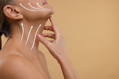 Woman with perfect skin after cosmetic treatment on beige background, space for text. Lifting arrows on her neck and face