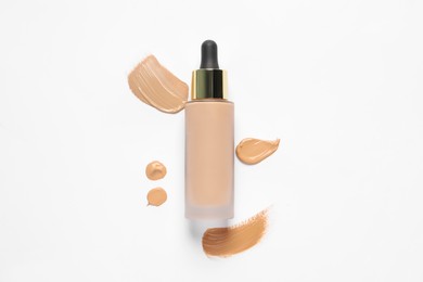 Photo of Liquid foundation and swatches on white background, top view