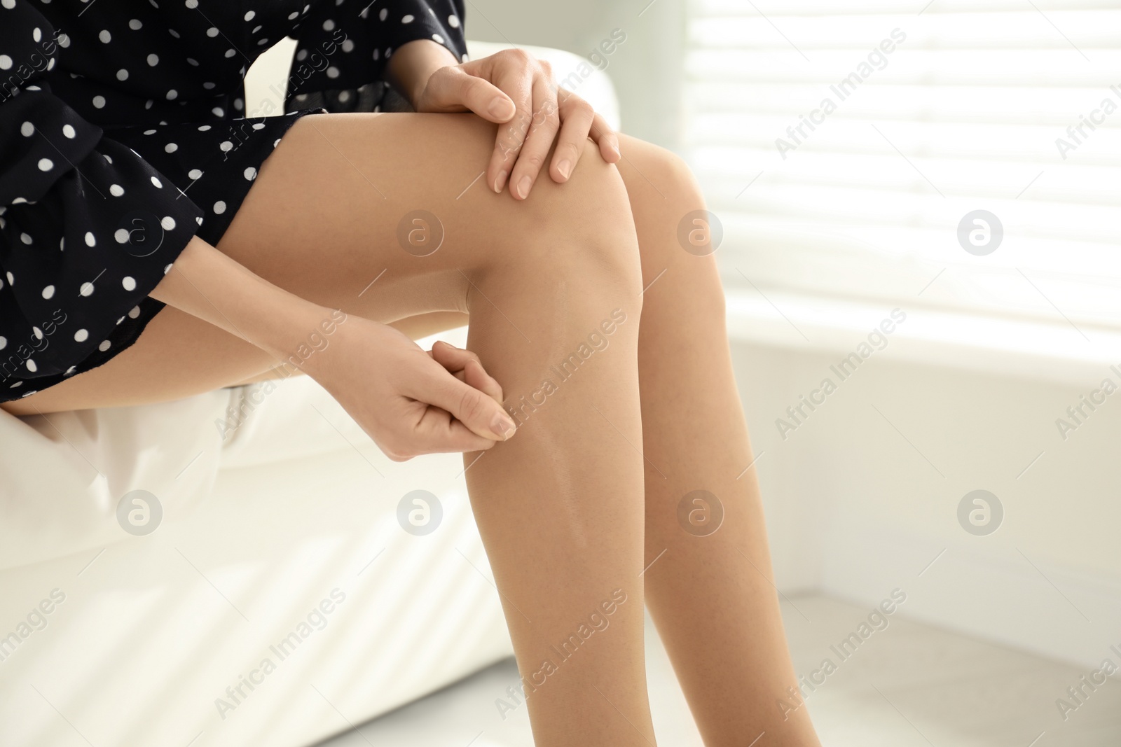 Photo of Woman wearing torn tights at home, closeup