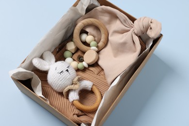 Photo of Different baby accessories in box on light blue background