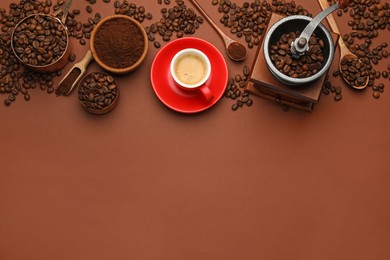 Flat lay composition with coffee grounds and roasted beans on brown background, space for text