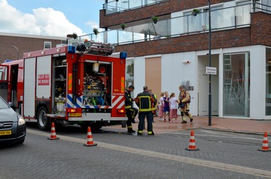 Photo of Oude Pekela, Netherlands - June 14, 2022: Modern red fire truck near building on city street