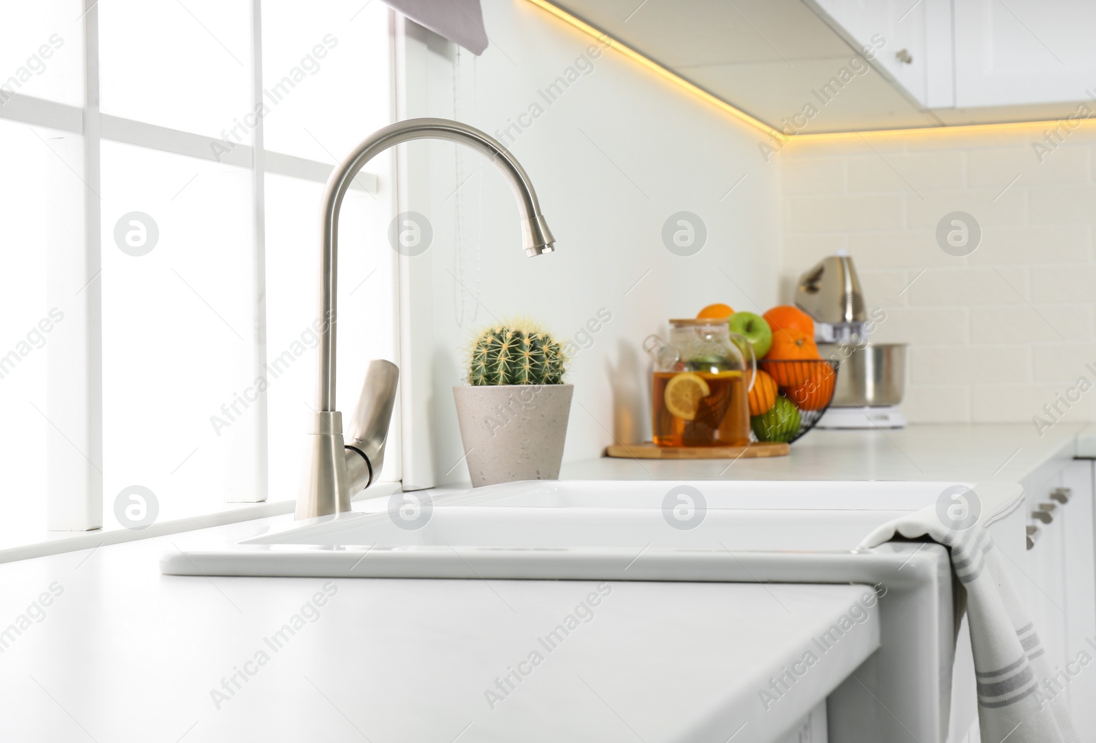 Photo of Ceramic sink and modern tap in stylish kitchen interior