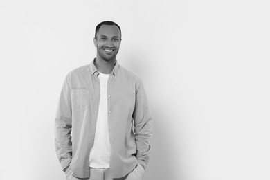 Portrait of handsome young man on light background, space for text. Black and white effect