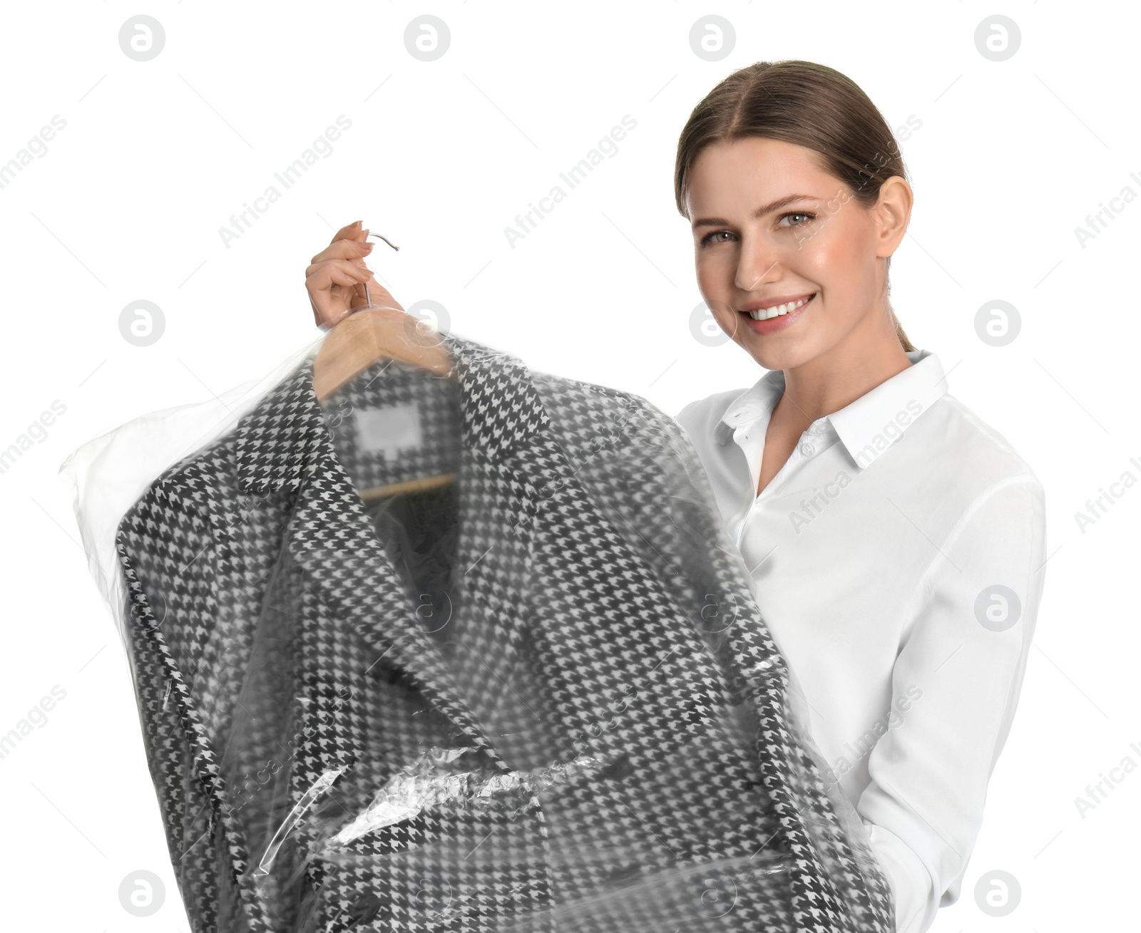 Photo of Young woman holding hanger with jacket in plastic bag on white background. Dry-cleaning service