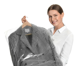 Young woman holding hanger with jacket in plastic bag on white background. Dry-cleaning service