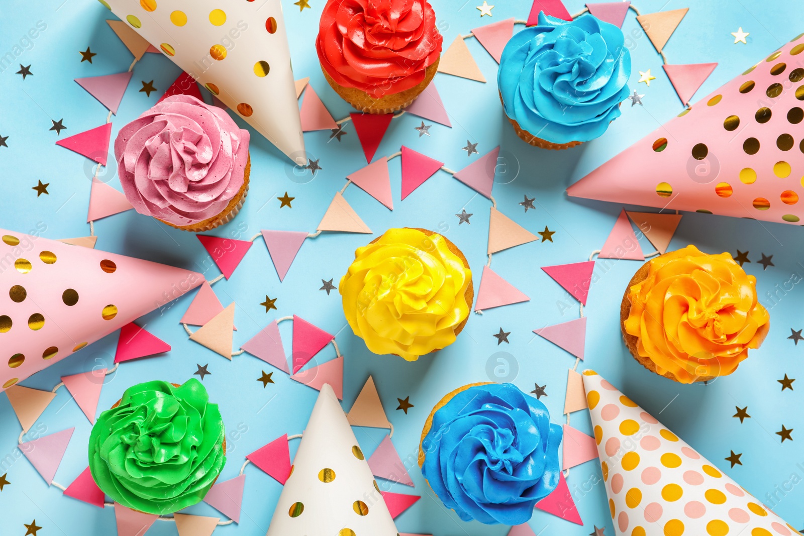 Photo of Flat lay composition with colorful birthday cupcakes on color background