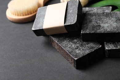 Photo of Natural tar soap on black table, closeup