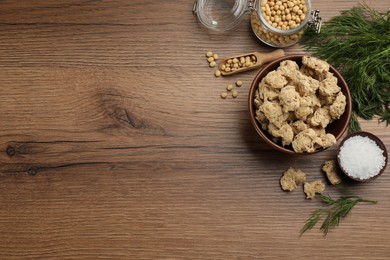 Photo of Flat lay composition with dried soy meat on wooden table. Space for text