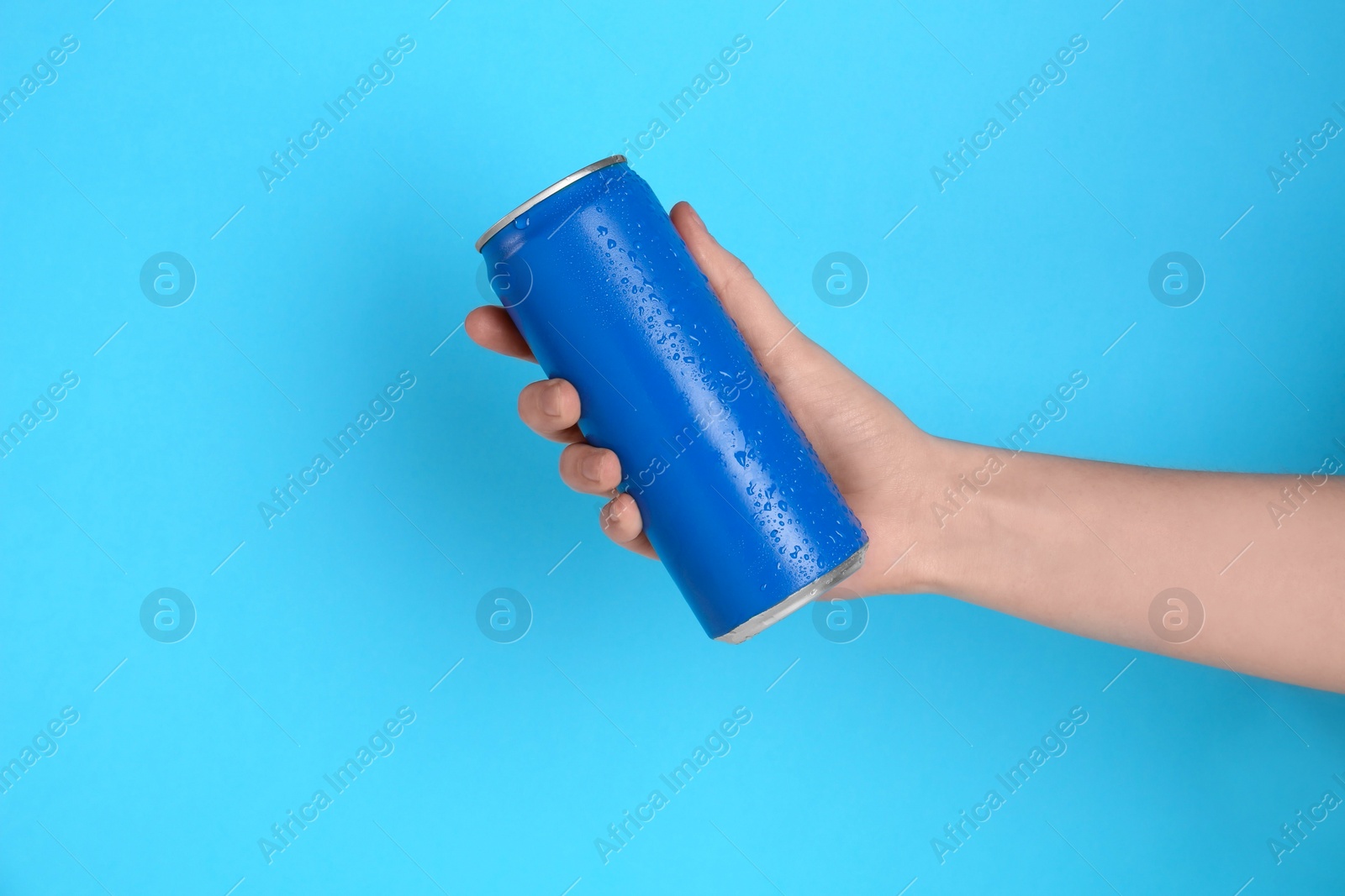 Photo of Woman with energy drink on light blue background, closeup