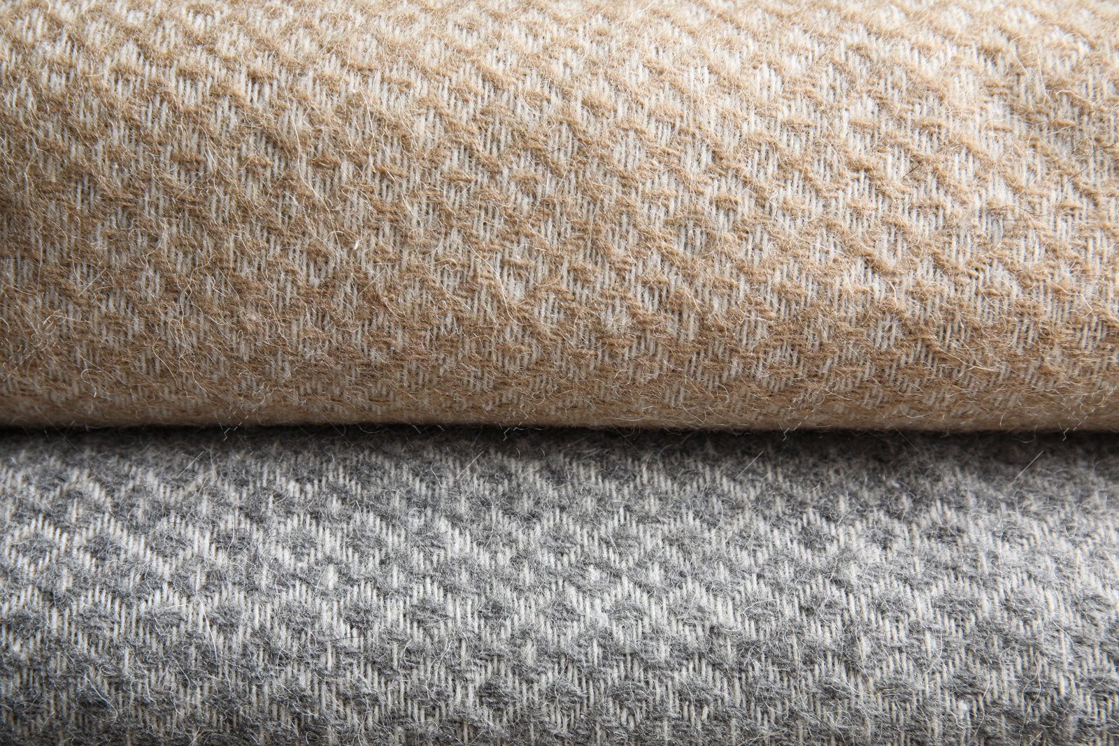 Photo of Beige and grey woolen plaids as background, closeup