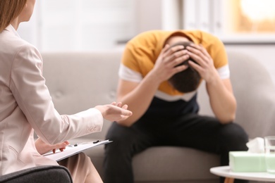 Photo of Psychotherapist working with young man in office