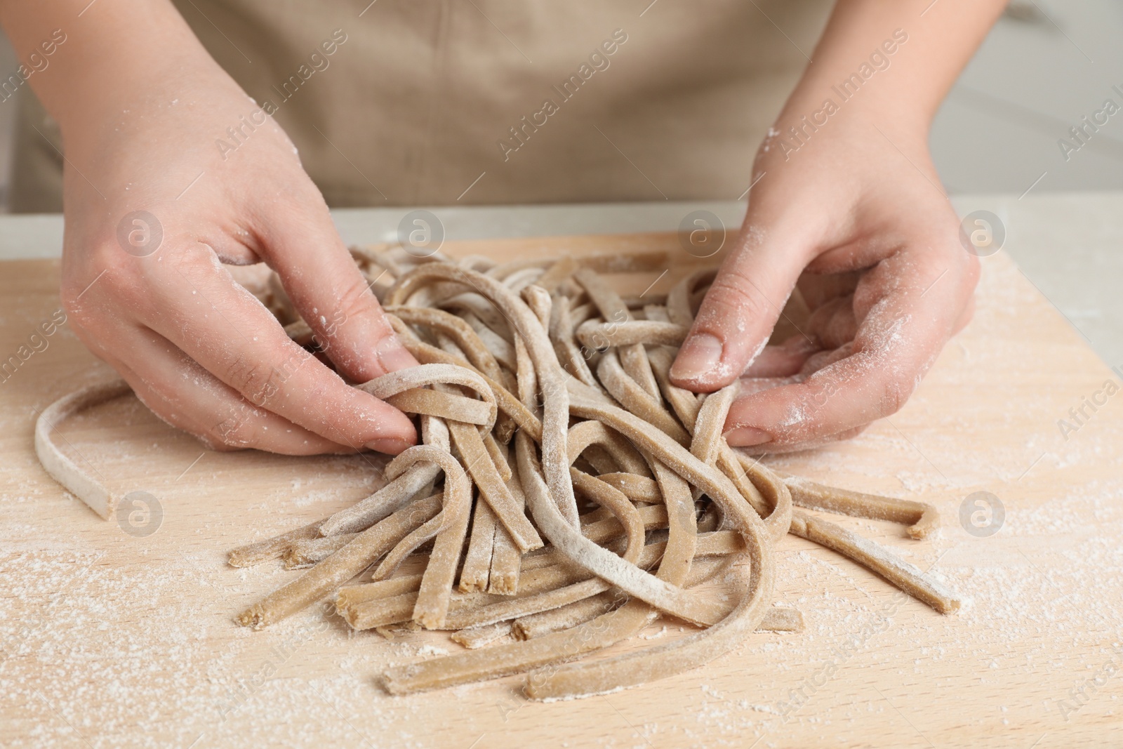 Photo of Woman with soba (buckwheat noodles) at wooden table, closeup