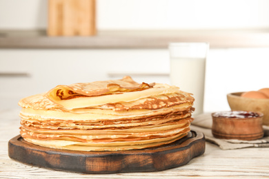 Photo of Fresh thin pancakes on white wooden table