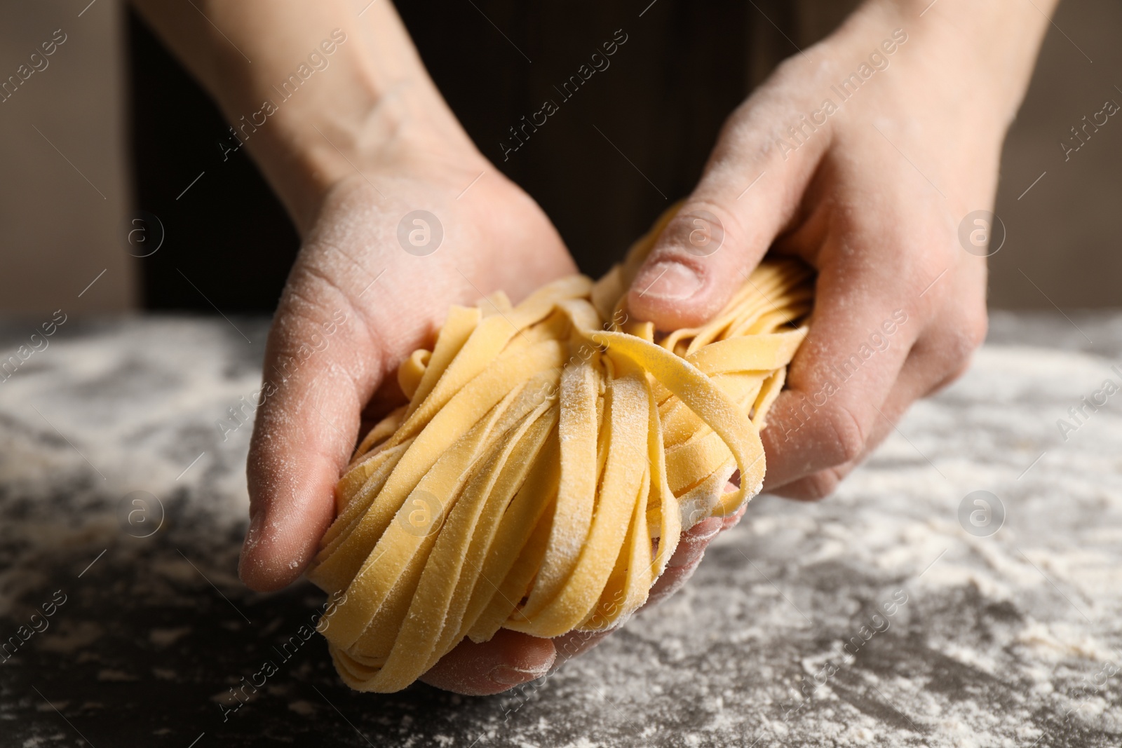 Photo of Woman holding pasta at table, closeup view