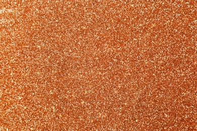 Beautiful shiny orange glitter as background, closeup