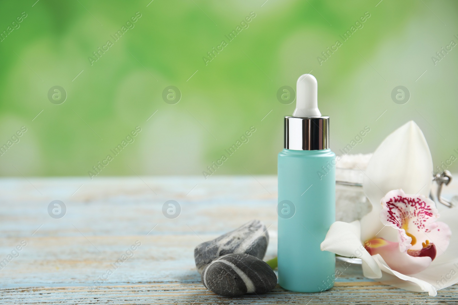 Photo of Composition with spa cosmetic and orchid flower on light wooden table, closeup. Space for text