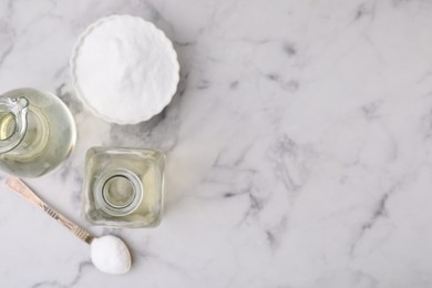 Vinegar and baking soda on white marble table, flat lay. Space for text