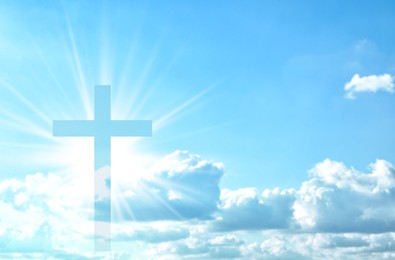 Image of Silhouette of cross against blue sky. Christian religion