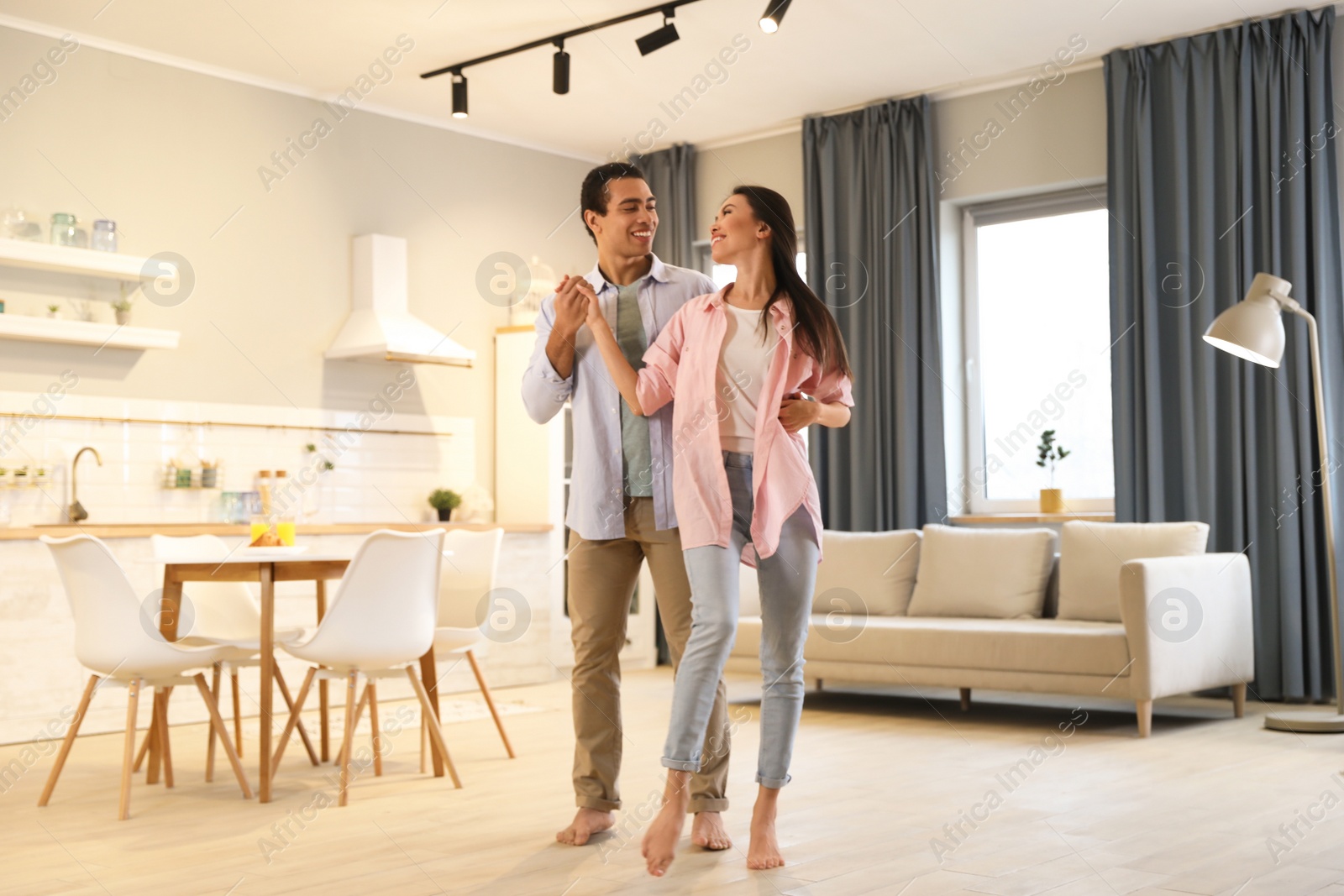 Photo of Lovely young interracial couple dancing at home