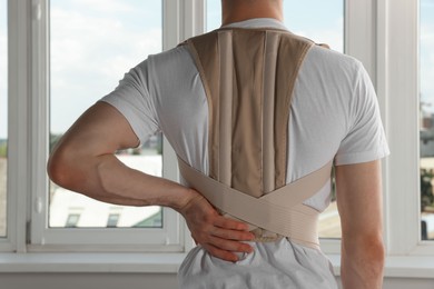 Photo of Closeup of man with orthopedic corset indoors, back view