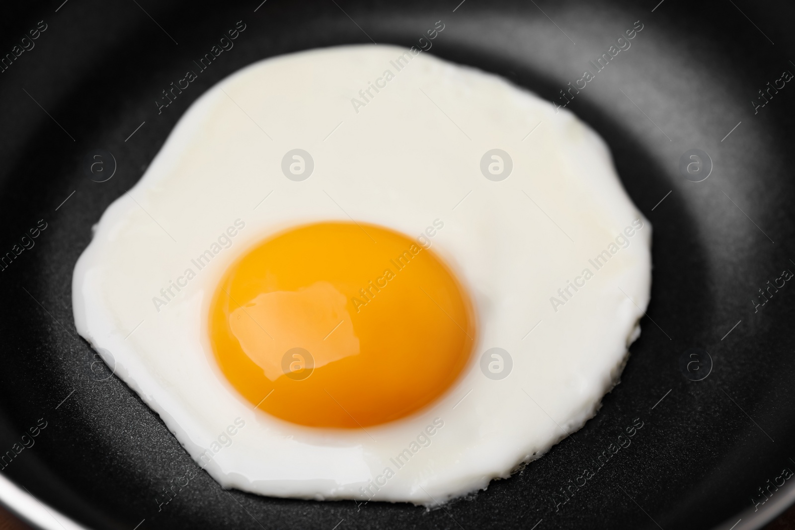 Photo of Tasty fried egg in pan, closeup view