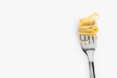 Fork with tasty pasta on white background, top view. Space for text