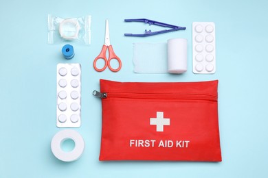 Photo of Flat lay composition with first aid kit on light blue background