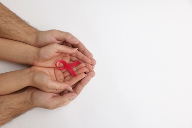 Photo of Couple holding pink ribbon on white background, top view with space for text. Breast cancer awareness