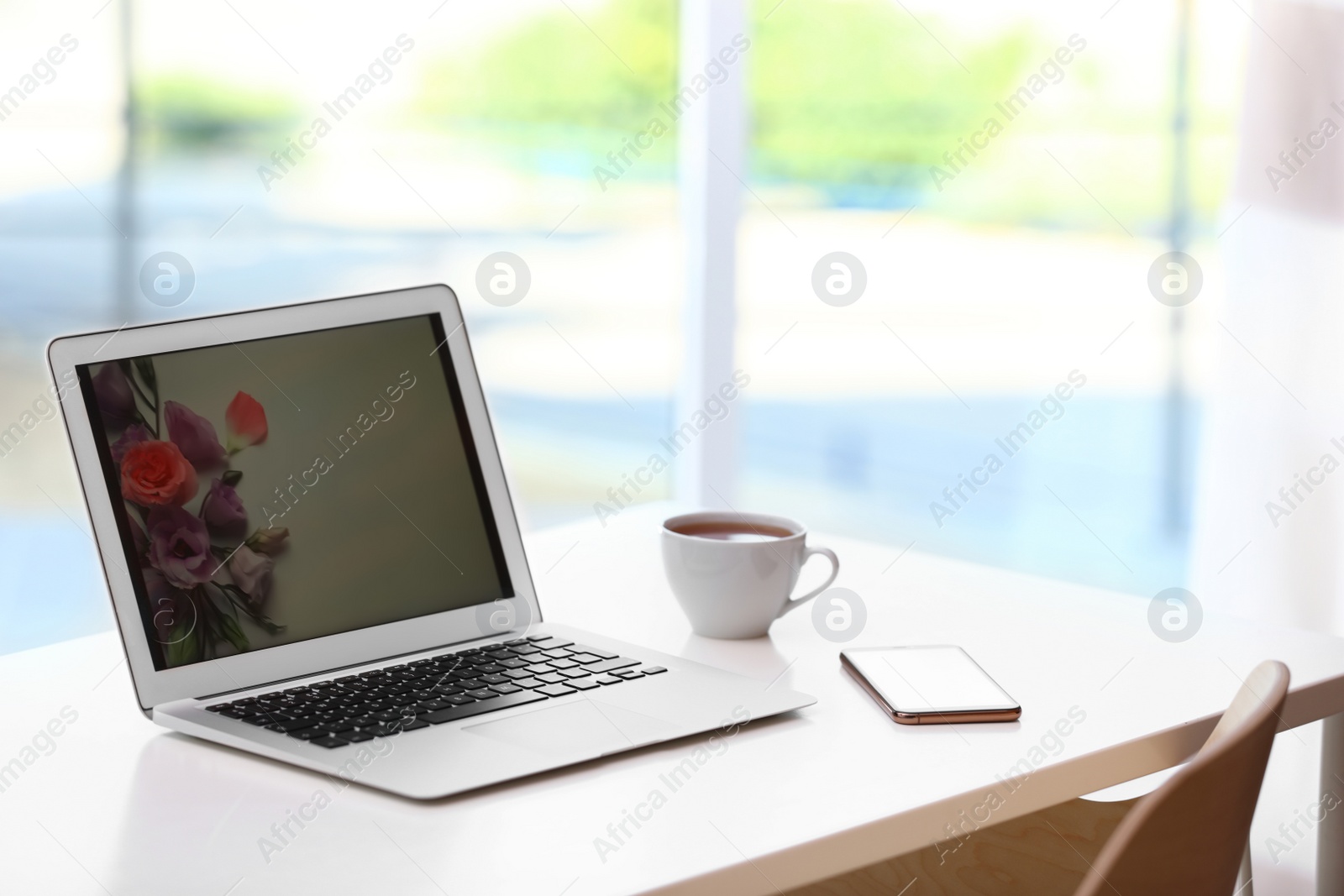 Photo of Comfortable workplace with modern laptop on desk in home office, space for text