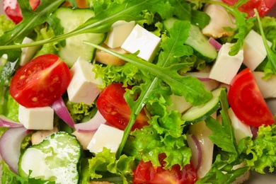 Delicious salad with meat, arugula and vegetables as background, closeup