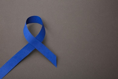 Blue ribbon on grey background, top view with space for text. Symbol of social and medical issues