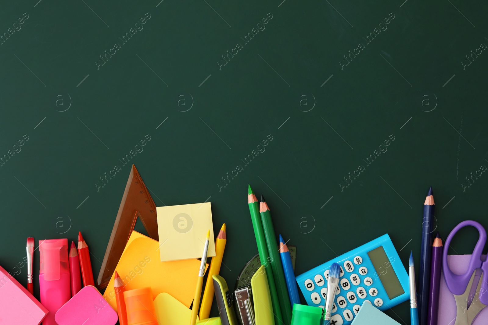 Photo of Flat lay composition with different school stationery on green chalkboard, space for text. Back to school