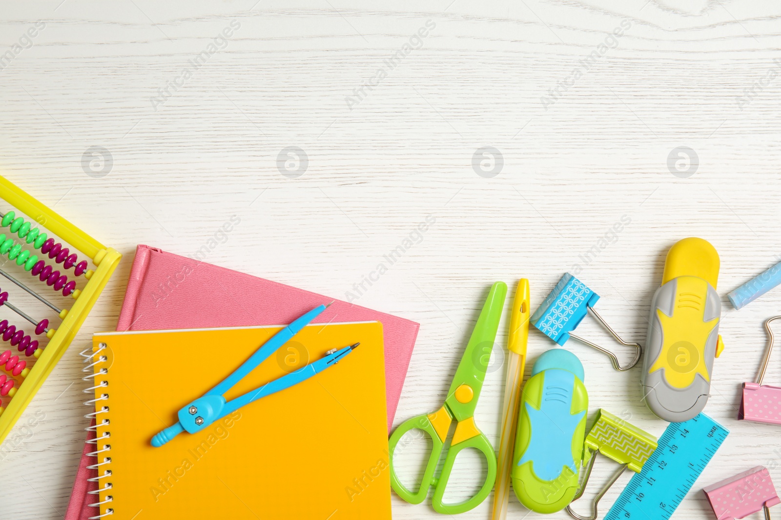 Photo of Different school stationery with space for design on wooden background, flat lay