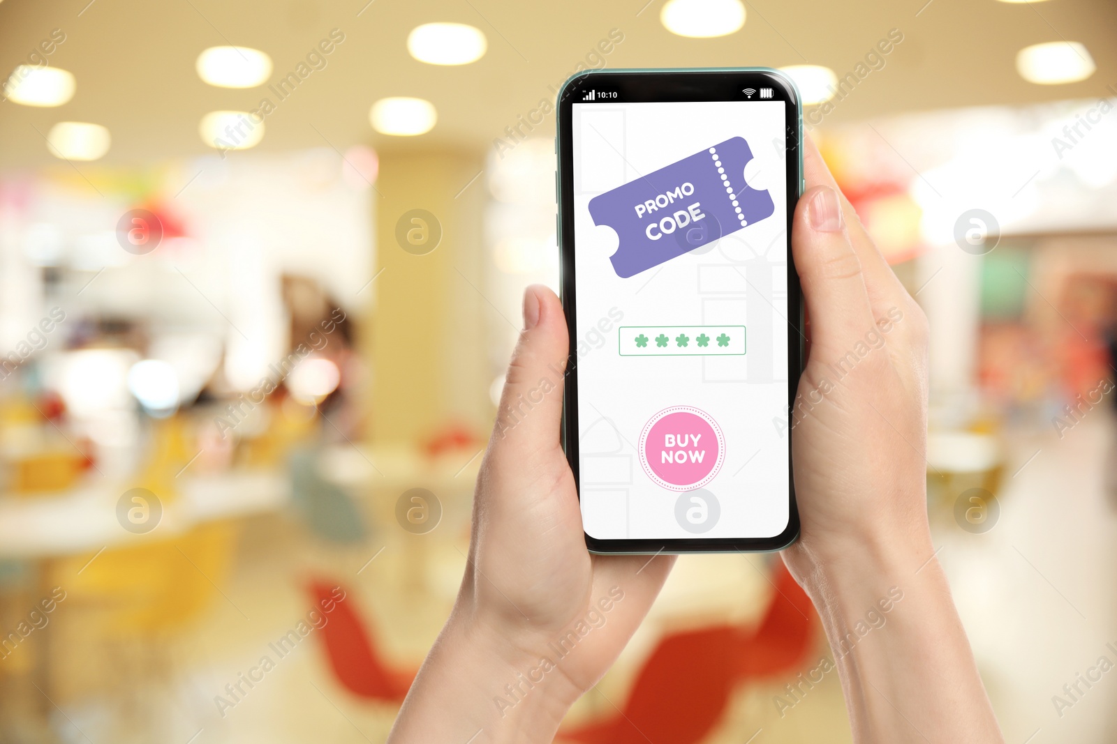 Image of Woman holding smartphone with activated promo code in shopping mall, closeup