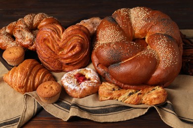 Different tasty freshly baked pastries on wooden table