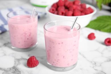 Tasty fresh raspberry smoothie on white marble table