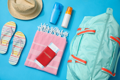 Flat lay composition with bag and travel accessories on blue background