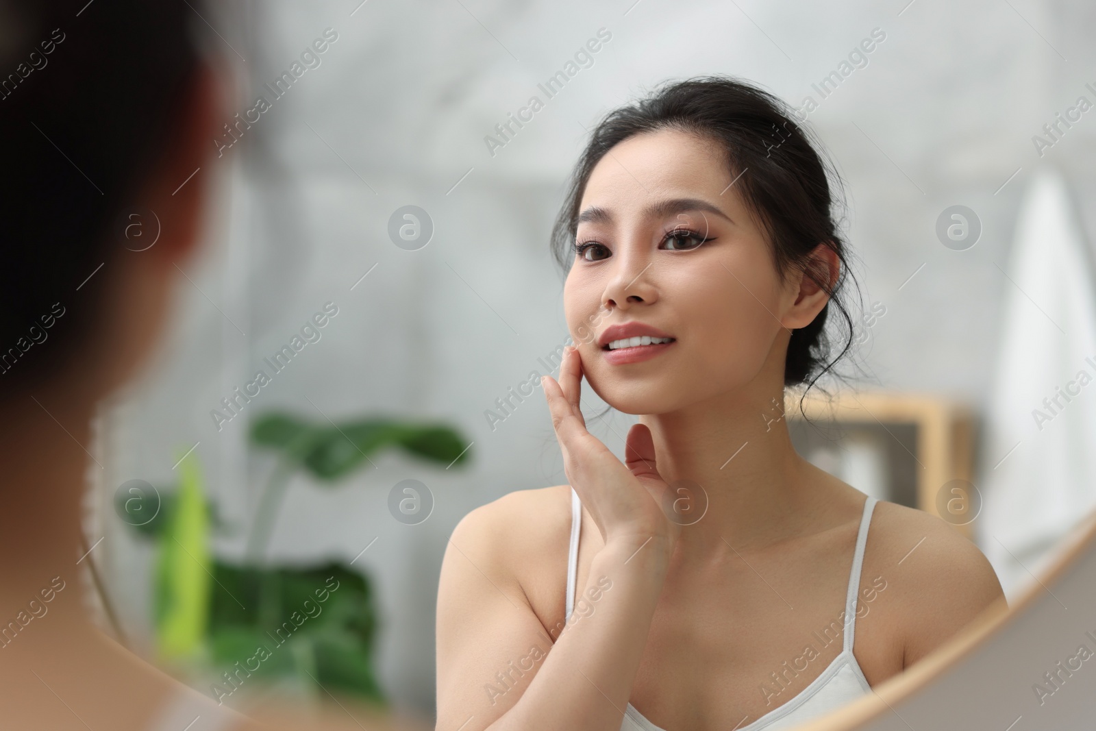 Photo of Portrait of beautiful woman near mirror indoors