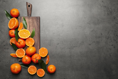 Fresh ripe tangerines and space for text on dark grey table, flat lay. Citrus fruit