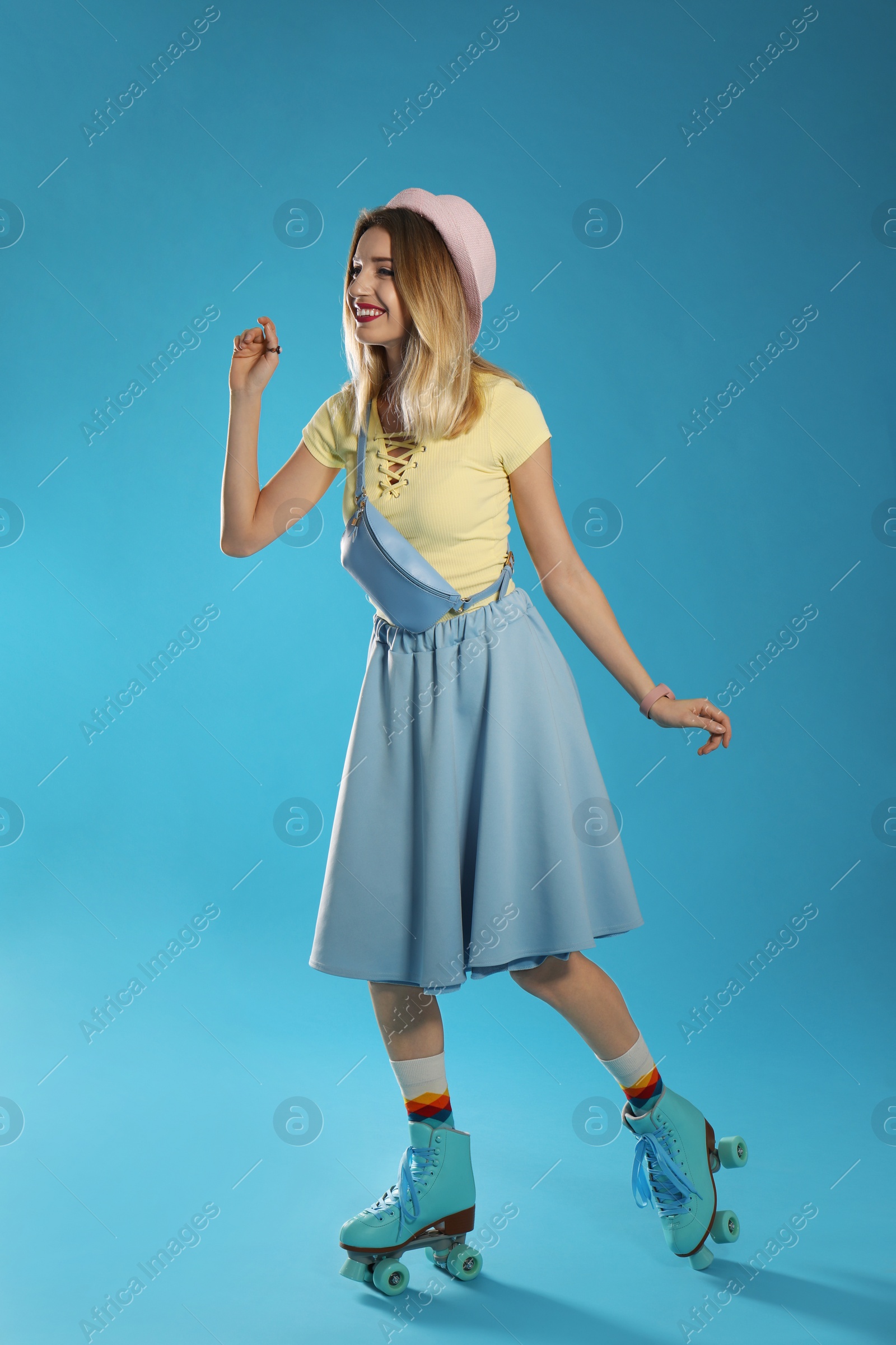 Photo of Young woman with retro roller skates on color background