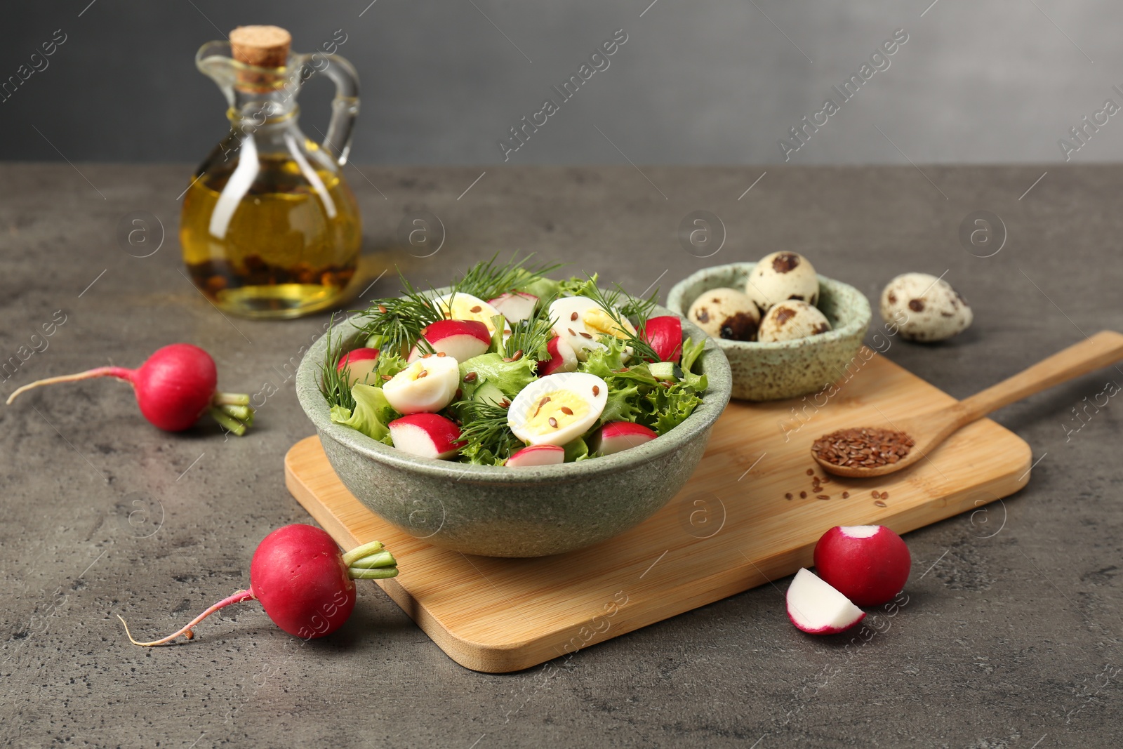 Photo of Delicious radish salad and ingredients on grey table