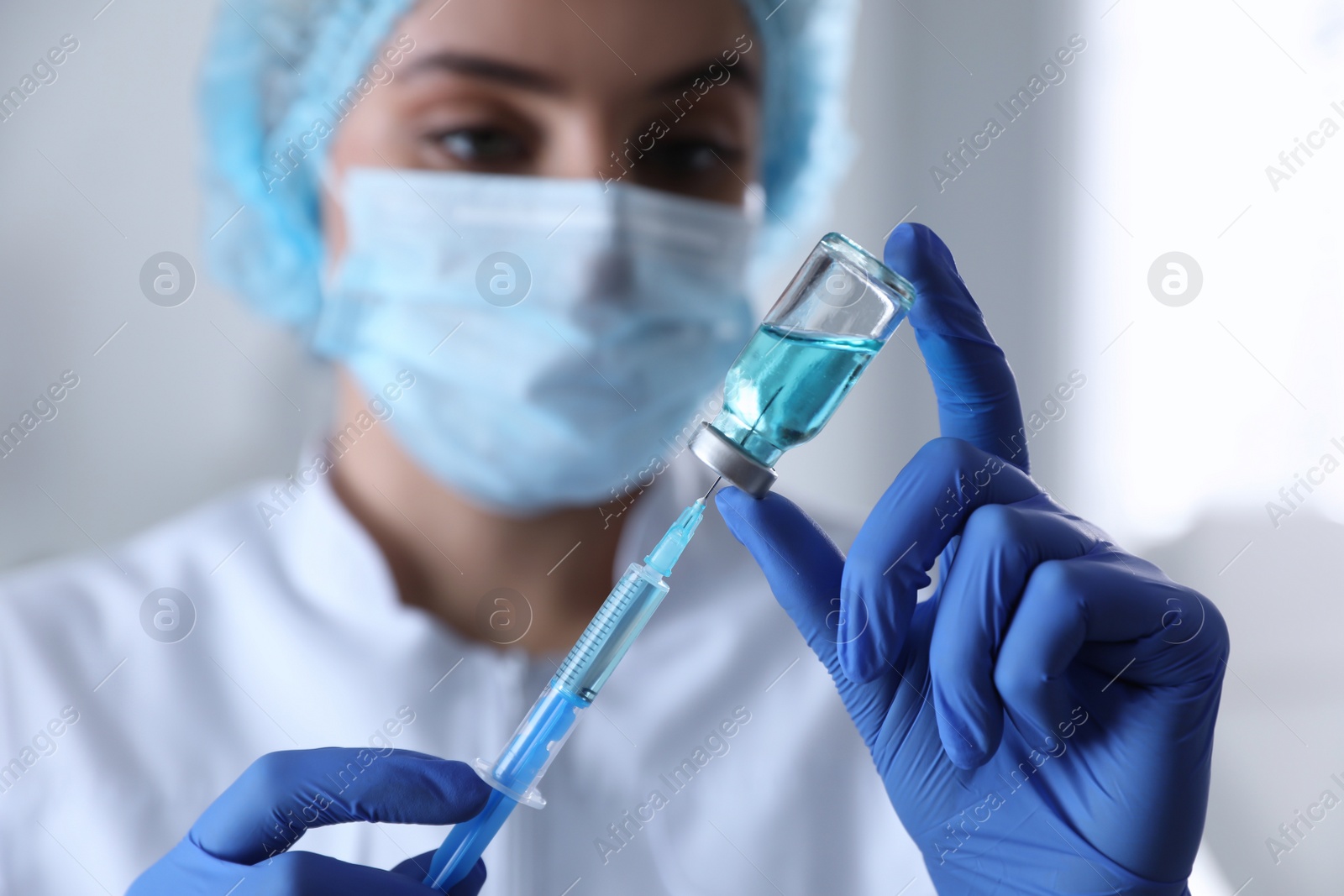 Photo of Doctor filling syringe with medication in clinic, focus on hands. Vaccination and immunization