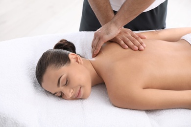 Photo of Relaxed woman receiving back massage in wellness center