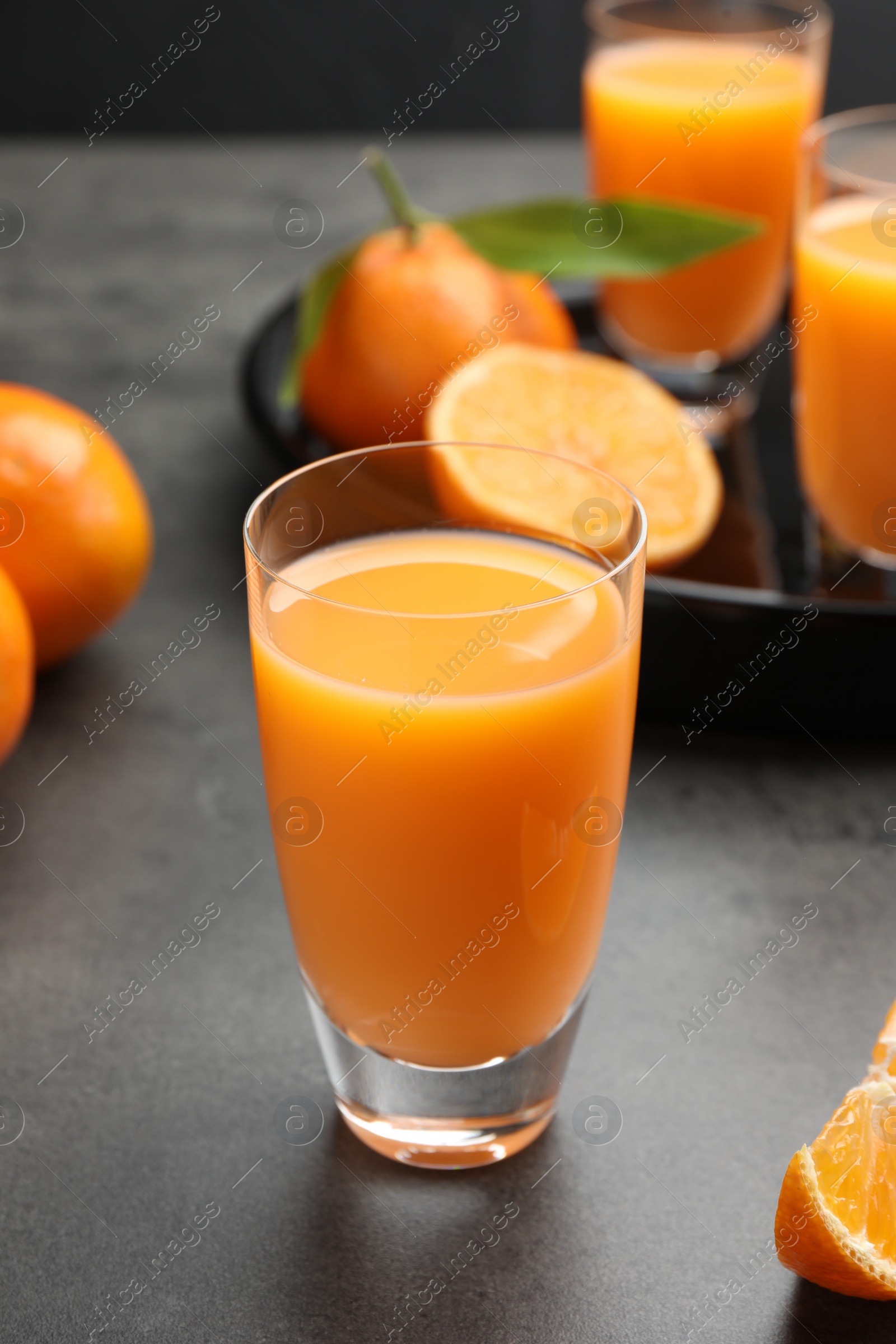 Photo of Delicious tangerine liqueur and fresh fruits on grey table, closeup